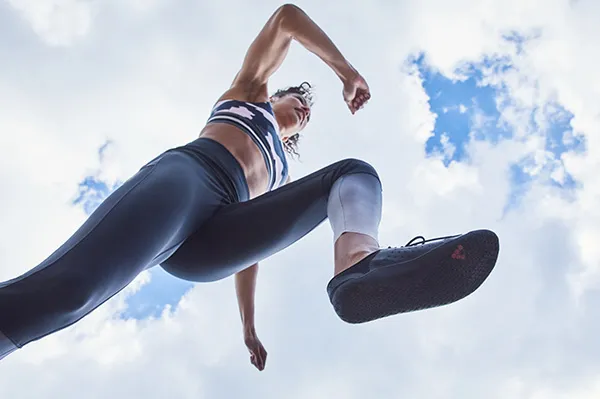 a woman running in vivo barefoot running shoes